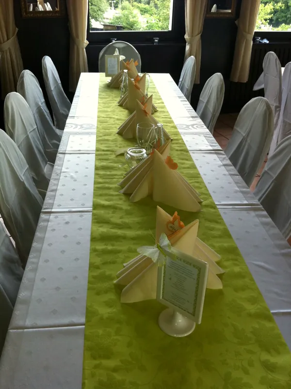 Lange Tafel mit grünem Läufer, Schmetterlingsdeko und Menükarte